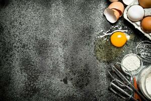 Baking background.Fresh eggs from the scattered flour. photo