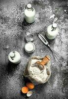 Baking background. Flour with fresh milk in bottles, sour cream and eggs. photo