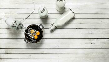 Baking background. Fresh eggs with a mixer. photo