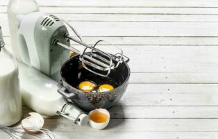 Baking background. Fresh eggs with a mixer. photo