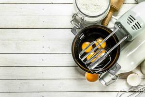 Baking background. Fresh eggs with a mixer. photo