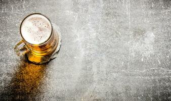 Beer in a glass on old stone surface. photo