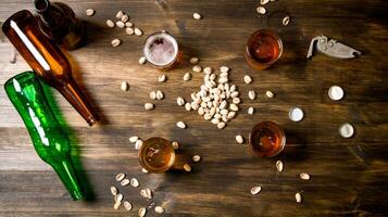 Four Beers with pistachios on a black wooden table. photo