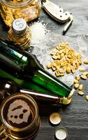 Beer with peanuts on the black wooden table. photo