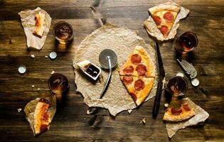 Pepperoni pizza and beer for four people. On a wooden table. photo