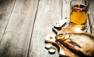 Smoked fish and fresh beer on wooden table. Free space for text. photo