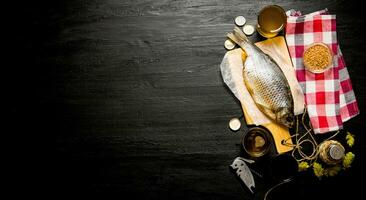 Dried fish and fresh beer on a chalkboard. Free space for text. photo