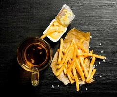 Fresh beer and fries with mustard sauce on the chalkboard. photo