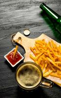 Beer and fries with tomato sauce on the chalkboard. photo