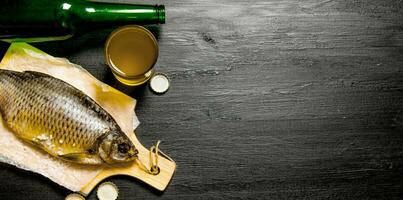 Dried fish and fresh beer on a chalkboard. photo