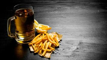 Fresh beer and fries with mustard sauce on the chalkboard. Free space for text. photo