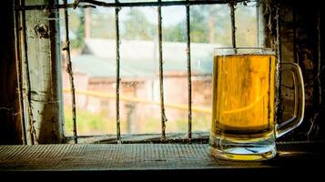 vaso de Fresco cerveza en de madera estante. en el antecedentes de un antiguo ventana. foto