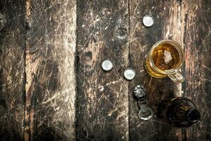 Fresh beer in a glass with stoppers and a bottle opener. photo