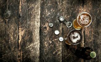 Fresco cerveza en un vaso con tapones y un botella abrelatas. foto