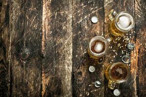 Fresco cerveza en un vaso con tapones y un botella abrelatas. foto