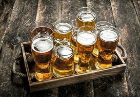 Glasses with fresh beer on an old tray. photo
