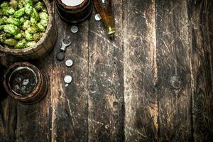 Beer in a wooden mug with green hops. photo