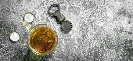 glass of beer with a bottle opener and stoppers. photo