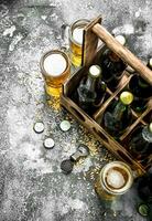 Beer background. Fresh beer in glasses and an old box. photo