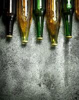 Different bottles of beer. On rustic background. photo