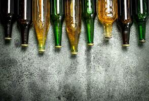 Different bottles of beer. On rustic background. photo