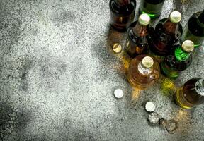 Different bottles of beer. On rustic background. photo