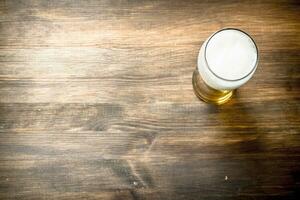 mug of fresh beer. On wooden table. photo