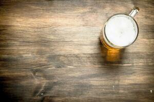 mug of fresh beer. On wooden table. photo