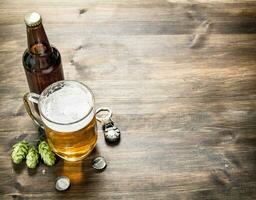 vaso de cerveza con tapones y un botella abrelatas. foto