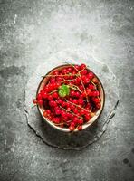 Red currant in the Cup. On stone table. photo