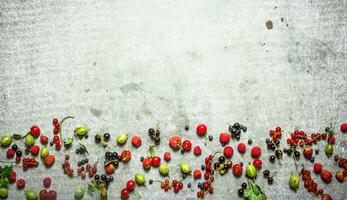 Different berries on the stone table. photo