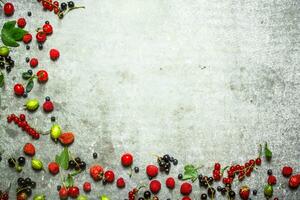 Different berries on the stone table. photo
