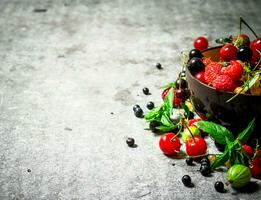 Berries in a Cup. On stone table. photo