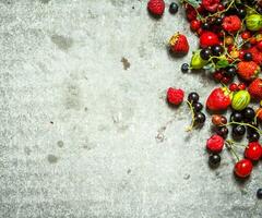 Different berries on the stone table. photo