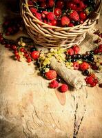 Basket with berries. On wooden table. photo