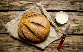 Fresh bread with knife and oil.  Top view photo
