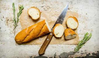 Ciabatta with herbs on paper. On rustic background. photo