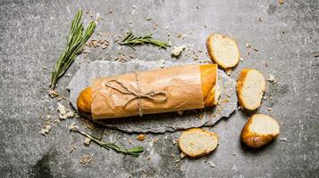 Fresh ciabatta with rosemary on a stone stand. photo