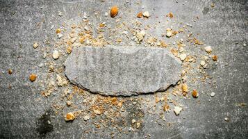 Bread crumbs and a stone stand.  Free space for text . photo