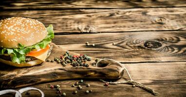 Burger on an old wooden Board with spices. photo