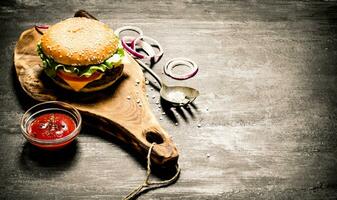 Cooked hamburger with ketchup and onion rings photo