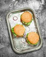 Burgers with beef and fresh vegetables on a steel tray. photo