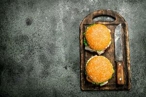 Burgers of fresh beef and vegetables on a cutting board. photo