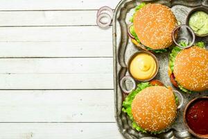 Burgers with beef and vegetables on a steel tray. photo