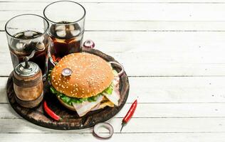 Fresh burger with cola on a wooden board. photo