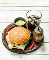 Fresh burger with cola on a wooden board. photo