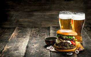 Street food. A big burger with glasses of light beer. photo