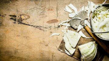 chopped cabbage in a pot and an old hatchet. photo