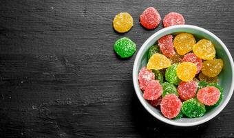 Fruit jelly in bowl. On black chalkboard. photo