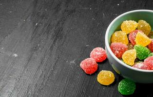 Fruit jelly in bowl. On black chalkboard. photo